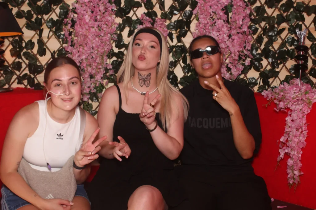 Drie gasten poseren met peaceteken in de caravan photobooth
